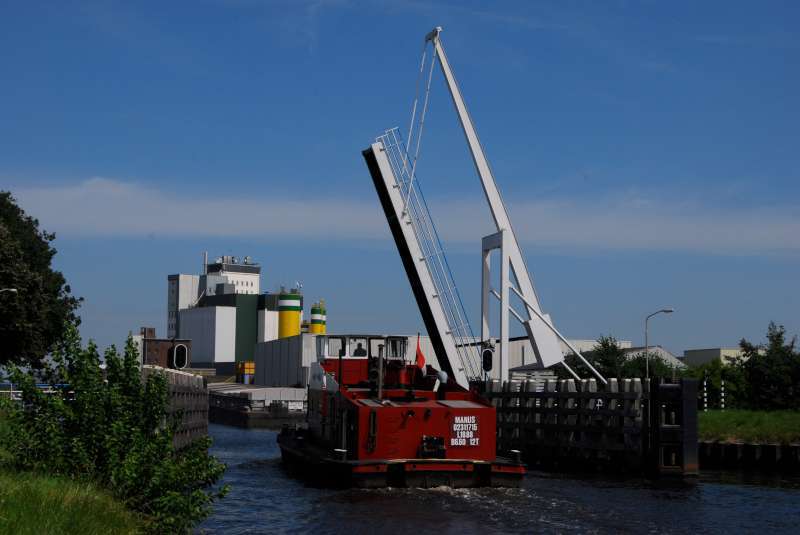 binnenvaartschip vaart onder geopende brug door